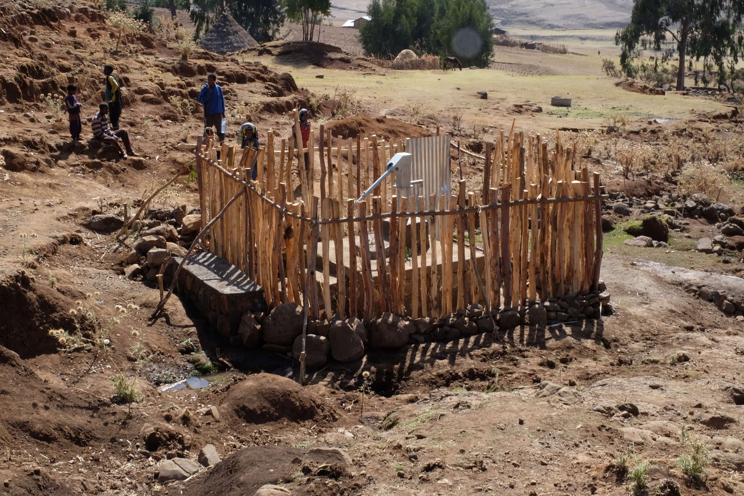 Fenced water source being admired by onlookers